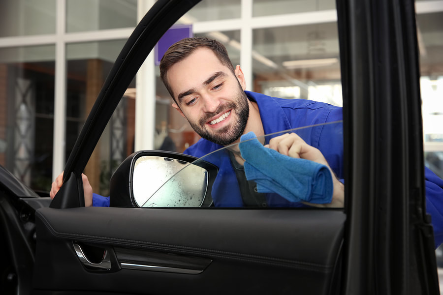 worker cleaning car window